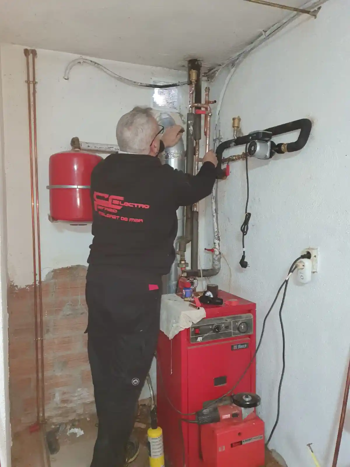 Técnico realizando servicios de climatización con instalación y reparación de caldera de calefacción.